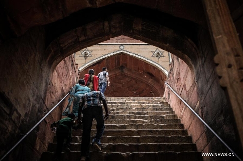 Tourists visit Humayun's Tomb in New Delhi, capital of India, May 12, 2013. Humayun's Tomb, located in east New Delhi, was built in 1569 to 1570 by Humayun's widow. As a precursor to the Taj Mahal, it stands on a platform of 12,000 square meters and reaches a height of 47 meters. The earliest example of the Persian influence in Indian architecture, the tomb itself is in the center of a large garden, surrounded by 12 hectares of gardens with pools joined by channels. The tomb brought Persian style to Delhi, but the two-tone combination of red sandstone and white marble is local, which shows the merging of different cultures. Humayun's Tomb was inscribed on the World Heritage List by the United Nations Educational, Scientific and Cultural Organization in 1993. (Xinhua/Zheng Huansong) 