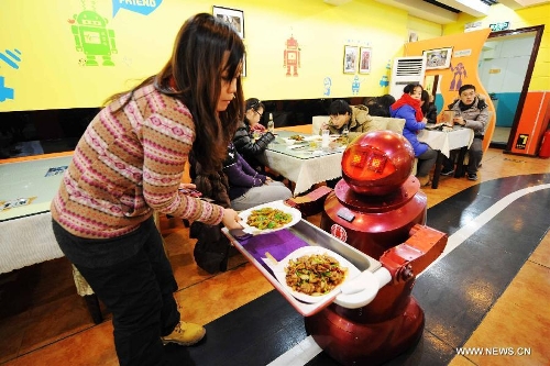 A robot serves dishes to a customer in a robot themed restaurant in Harbin, capital of northeast China's Heilongjiang Province, Jan. 18, 2013. Opened in June of 2012, the restaurant has gained fame by using a total of 20 robots to cook meals, deliver dishes and greet customers. (Xinhua/Wang Jianwei) 