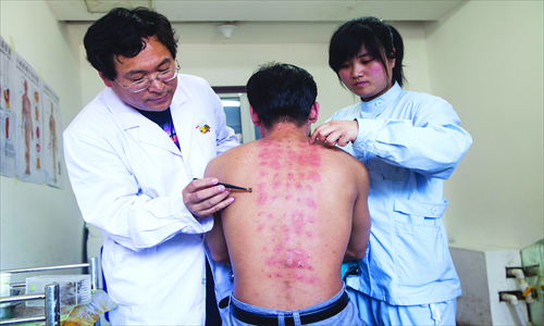 Doctors use tweezers to remove bee stingers from a patient's back. Photo:IC