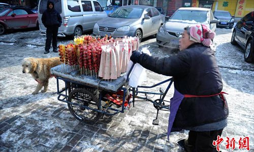Big Yellow and his owner sell Bingtanghulu, February 6, 2013. Photo: Chinanews.com
