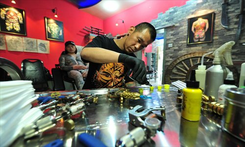 A tattoo artist from Taiyuan, Shanxi Province, mixes pigments in his shop. Photo: CFP