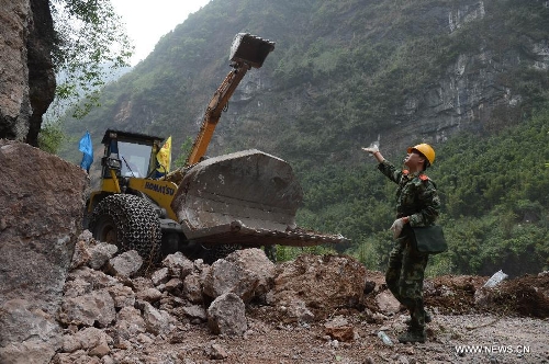 Excvavtors work to clear the way liking the quake-hit Lushan County to Lingguan Town of Baoxing County in southwest China's Sichuan Province, April 21, 2013. After two days of work, traffic was preliminarily restored on Sunday on a quake-damaged section of the S210 highway that connects the isolated Baoxing County with neighboring Lushan County, the epicenter of the quake. More rescue and relief supplies have been transported to the county through the highway. (Xinhua/Liu Haishan) 