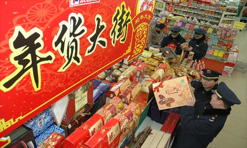 Employees from the Tongzhou district administration for industry and commerce inspect packed goods at a supermarket Wednesday. Photo: Courtesy of the administration