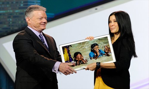 Panasonic North America CEO Joe Taylor hands over Panasonic's new 20-inch tablet, which boasts a 4K display, to host Lisa Ling at a keynote speech at the 2013 International CES on Tuesday in Las Vegas, Nevada. CES, the world's largest consumer technology trade show, runs through Friday and will feature 3,100 exhibitors showing products to about 150,000 attendees. Photo: AFP