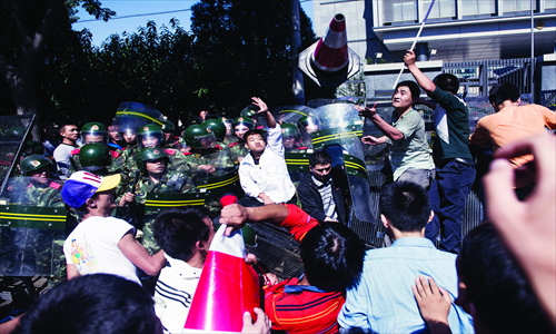 Riot police try to stop furious protestors from breaking into the embassy on Saturday. Photo: Li Hao/GT