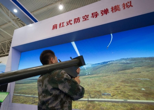 An assistant demonstrates a simulated shoulder-fired anti-aircraft missile during a science exhibition in Beijing, capital of China, May 19, 2013. The exhibition is a part of the National Science and Technology Week and will last till May 25. (Xinhua/Luo Xiaoguang)&nbsp; 