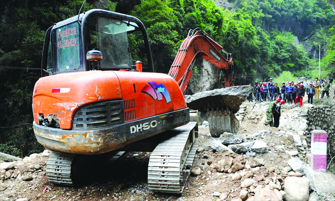 An excavator clears a blocked road, the only rescue channel leading out of Baoxing county on Sunday. Photo: Li Hao/GT