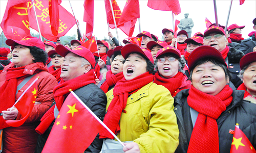 Visitors to Chairman Mao Square sing revolutionary songs. Photo: Liang Chen/GT