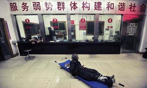 Hands and feet tied, a homeless man lies on a stretcher in the reception hall at a rescue center in Changsha, Hunan Province. Photo: CFP