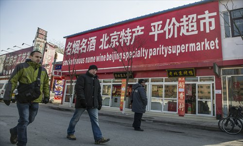 Two foreigners pass a curiously named store on Wangfujing Dajie, Dongcheng district Wednesday. Photo: Li Hao/GT