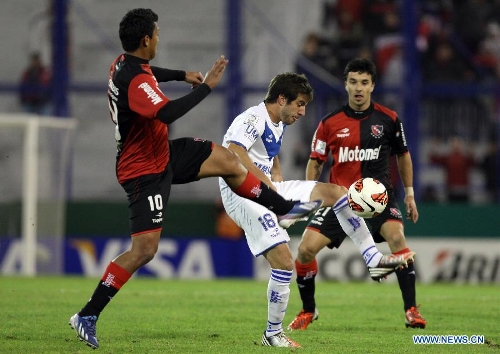Francisco Cerro (C) of Velez Sarsfield vies for the ball with Rinaldo Cruzado (L) and Ignacio Scocco (R) of Newell's Old Boys during the Copa Libertadores 2013 soccer match at Jose Amalfitani Stadium, in Buenos Aires, Argentina, on May 15, 2013. (Xinhua/Martin Zabala) 