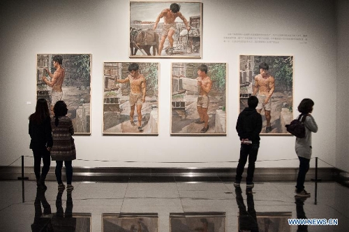 Visitors look at paintings by Lin Xudong during the 