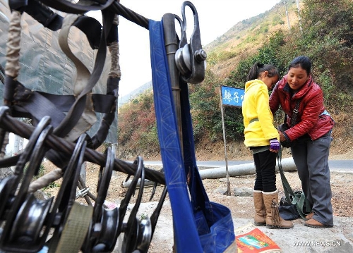 Residents from Shuangmidi Village make preparations before crossing the Nujiang River via a zip-line in Liuku County of Nujiang Lisu Autonomous Prefecture, southwest China's Yunnan Province, Feb. 2, 2013. More than 98 percent of Nujiang Lisu Autonomous Prefecture is occupied by mountains and valleys. The zip-lines have been quite popular transportation method along the Nujiang River since the ancient time. However, as transport conditions improve in recent years, a growing number of traditional zip-lines along the Nujiang River Valley have been dismantled or replaced by bridges. (Xinhua/Wang Changshan)  