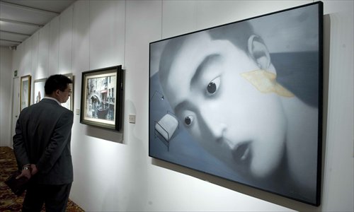 A man views a Christie's preview of Zhang Xiaogang's paintings in Beijing in October 2012. Photo: CFP