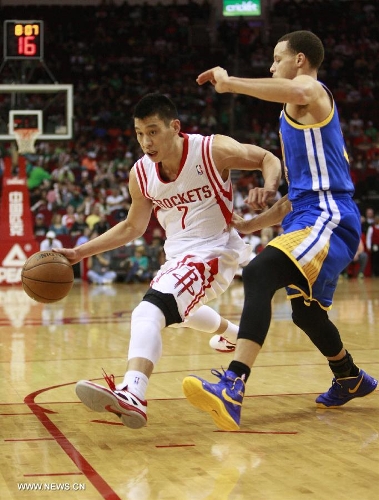 Jeremy Lin (L) of Houston Rockets drives the ball during the NBA game against Golden State Warriors in Houston, the United States, on March 17, 2013. (Xinhua/Song Qiong) 