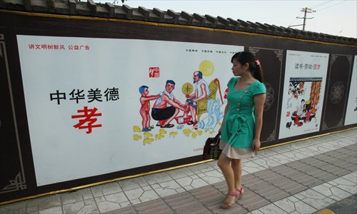 A pedestrian eyes the PSA posters featuring the work of Liu Zhigui. Photo: CFP