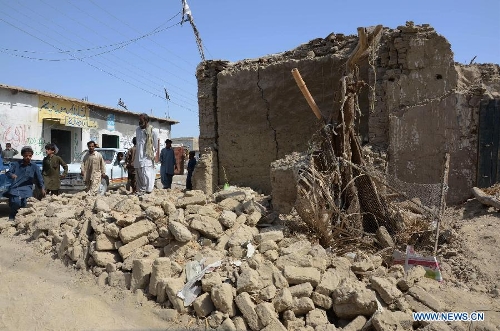 Pakistani earthquake survivors walk past collapsed mud houses in southwest Pakistan's Mashkel area, April 19, 2013. Pakistani authorities on Thursday said that rescue operations had been speeded up in areas affected by the Tuesday's 7.9 magnitude earthquake in the country's southwestern province of Balochistan near Pakistan-Iran border. At least 40 people were killed and over 300 others injured in a 7.9-magnitude earthquake that hit Pakistan on Tuesday afternoon, an official with National Disaster Management Authority (NDMA) told Xinhua on Wednesday. (Xinhua/Asad) 
