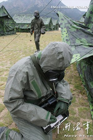 A shore-based mobile anti-ship-missile regiment under the South China Sea Fleet of the Navy of the Chinese People’s Liberation Army (PLA) organized a NBC (nuclear, biological and chemical) defense drill against actual-combat background on April 7, 2013. The picture shows the officers and men of the regiment are carrying out decontamination and detection of chemical agents in the infected “toxic” areas. (China Military Online/Sheng Yuehua, Zhao Changhong and Zheng Can)