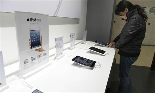 A customer tries on Apple's iPad mini, at an authorized store in Wuhan, capital of central China's Hubei Province, Dec. 7, 2012. Apple's iPad mini and the fourth-generation iPad went on the Chinese mainland market on Friday.Photo: Xinhua