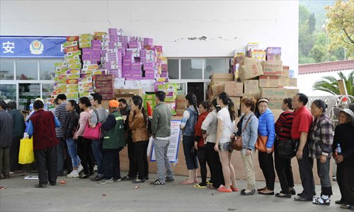 Local residents in Lushan line up to receive aid outside Lushan Middle School on April 25. Photo: Li Hao/GT