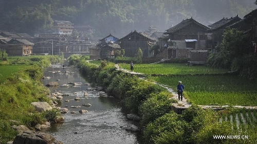 (130621) -- LIPING, June 21, 2013 (Xinhua) -- People walk on a pathway in Dimen Dong minority village in Liping County of southwest China's Guizhou Province, June 21, 2013. Dimen is a Dong minority village with about 2,500 villagers. It is protected properly and all the villagers could enjoy their peaceful and quiet rural life as they did in the past over 700 years. (Xinhua/Ou Dongqu) (yxb) Photo taken on June 21, 2013 shows the Dimen Dong minority village in the morning in Liping County of southwest China's Guizhou Province. Dimen is a Dong minority village with about 2,500 villagers. It is protected properly and all the villagers could enjoy their peaceful and quiet rural life as they did in the past over 700 years. (Xinhua/Ou Dongqu)