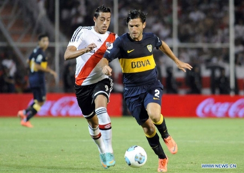 Christian Cellay (R) of Boca Juniors vies for the ball with Gabriel Funes (L) of River Plate during the second match of the 