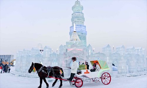 Tourists take a carriage at the 29th Harbin International Ice and Snow Festival in Harbin, capital of northeast China's Heilongjiang Province, December 23, 2012. The festival kicked off at the Harbin Ice and Snow World on Sunday. Photo: Xinhua