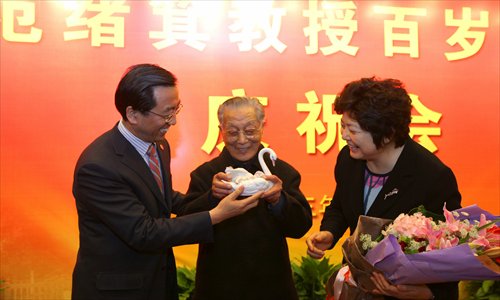 Former Shanghai Jiao Tong University President Fan Xuji, 99, receives a porcelain swan from current university President Zhang Jie at a birthday party Saturday at the school. Fan was the university's president in the early 1980s and is one of the oldest scientific researchers in the world. Photo: Cai Xianmin/GT