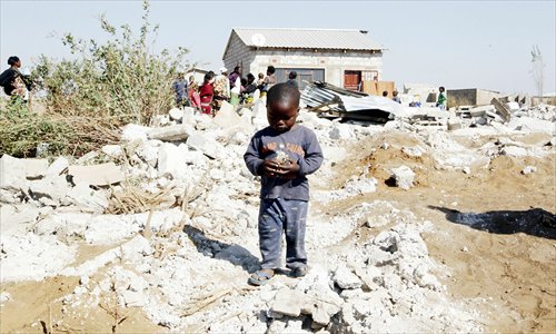 A boy identifies his toy from the rubble in Lusaka on Wednesday. Hundreds of Zambians faced a night on the streets after the authorities cleared their homes to make way for a milling company. Photo: IC 