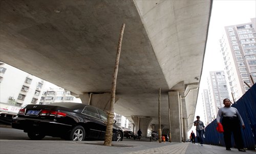 Trees without leaves try to grow under an expressway overpass in Zhengzhou, Henan Province. The local government, which planted the trees, says they will eventually turn green and benefit residents, while some forestry experts disagree and many citizens worry the trees will pose a danger to the overpass when they grow. Photo: CFP