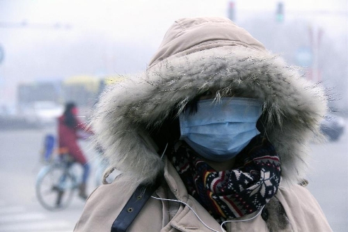 A citizen wearing face mask walk in fog in Liaocheng City, east China's Shandong Province, Feb. 17, 2013. (Xinhua/Zhang Xianju) 