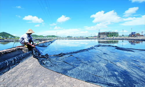 A worker puts up a waterproof barrier at the Cang'ao saltworks.Photo: CFP