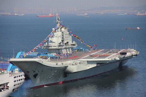 China's first aircraft carrier, which is being refitted at the port of Dalian, flew flags on Sunday. Photos show what looks like a ceremony is being held on the deck of the carrier. Photo: huanqiu.com