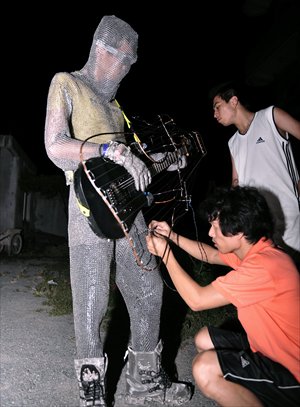 Wang Zengxiang (right) and his friend check the protective clothing of a guitar player before the performance. Photo: CFP