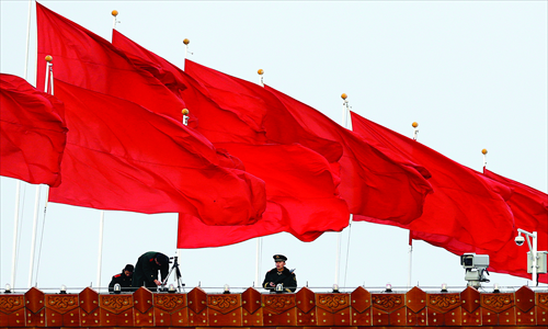 A security guard stands on top of a building near Tiananmen Square in Beijing on Wednesday, one day ahead of the 18th national Party congress. In addition to selecting members of the leading Party bodies, the 2,270 delegates will hear and deliberate the work of the Party over the past five years, a Party discipline report and revisions to the Party Constitution. Photo: IC