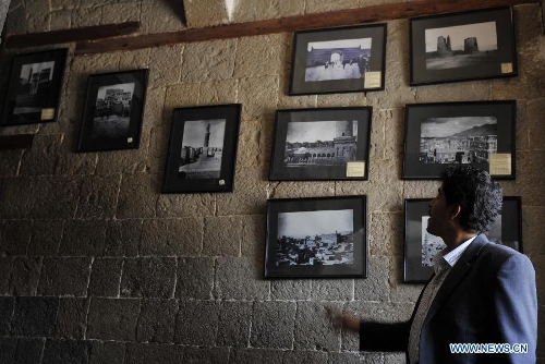 A visitor looks at the photos of Sanaa taken about 100 years ago, at the National Museum of Yemen in Sanaa, on May 5, 2013. (Xinhua/Mohammed Mohammed) 