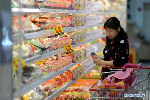 A consumer selects food at a supermarket in Hefei, capital of east China's Anhui Province, May 9, 2013. China's consumer price index (CPI), a main gauge of inflation, grew 2.4 percent year on year in April, up from 2.1 percent in March, the National Bureau of Statistics (NBS) said Thursday. The NBS attributed the gain mainly to an unusual increase in vegetable prices during that month as low temperatures and scarce rainfalls disrupted supplies. (Xinhua/Zhang Duan) 