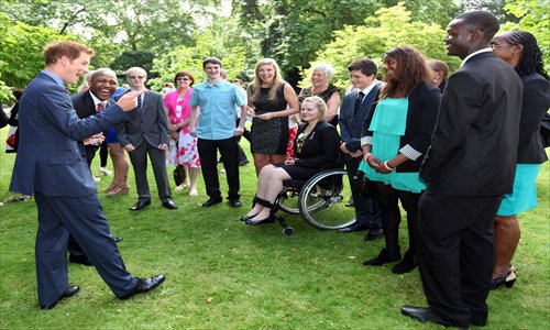 Britain's Prince Harry (left), president of The School Games, speaks to young athletes during a reception at Clarence House in London on August 2. Prince Harry met with about 25 athletes and congratulated them on winning medals during the Sainsbury's 2012 School Games, a multi-sport event for the UK's elite young athletes of school age. 