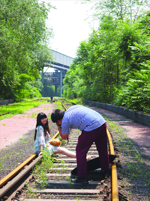Lu Yao poses on the derelict tracks of Shougang while her boyfriend snaps a photo. Photo: Jiang Yuxia/GT
