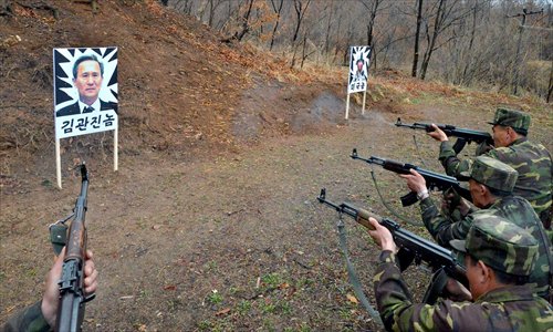 This photo released by North Korean media outlets Sunday show soldiers shooting at a straw man with a printed face of Kim Kwan-jin, defense minister of South Korea, during a training session. Photo: CFP