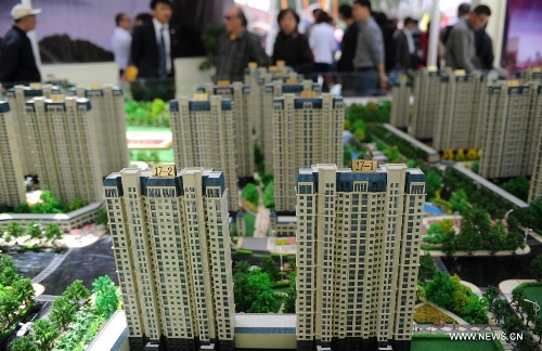 Visitors gather to learn housing information in front of a housing project at Shijiazhuang Spring Housing Fair in Shijiazhuang, capital of north China's Hebei Province, April 29, 2013. The fair, which kicked off on April 29, will last for four days. (Xinhua/Wang Xiao)&nbsp; 