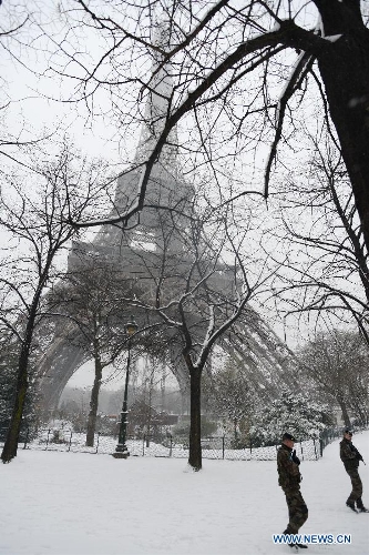 Soldiers patrol near the Eiffel Tower in Paris, France, Jan. 20, 2013. French weather agency Meteo France has put 55 departments, including the Ile-de-France (Paris and its suburb), under orange alert and decided to maintain the alert system in these areas till Sunday afternoon based on lasting snowfalls in these areas where the snow is expected to be thick as up to 20 centimeters. (Xinhua/Li Genxing)