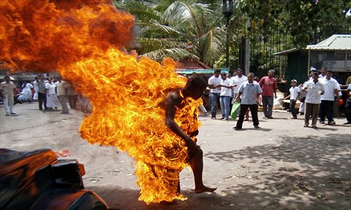 Sri Lankan Buddhist monk Bowatte Indaratane is engulfed in flames after he set himself on fire in the central town of Kandy on Friday. Indaratane self-immolated to protest the slaughter of cattle in the country, reports said. Policemen doused the flames and rushed the monk to a Colombo hospital where he arrived in a critical condition. Photo: AFP