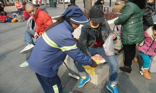 A cleaner in Shanghai South Railway Station hands a small plastic rubbish bag to passengers eating snacks during the Spring Festival. Photo: Courtesy of Li Guihong