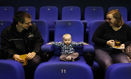 A baby attends a movie screening with his parents at the Pathe movie theater in Breda, The Netherlands, on Sunday. During special baby showings the lights stay on in the cinema, the sound is low and diapers can be changed. Photo: CFP
