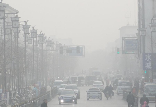 Citizens ride and vehicles run on a fog-shrouded road in Suzhou, east China's Jiangsu Province, Jan. 21, 2013. (Xinhua/Wang Jiankang) &nbsp;