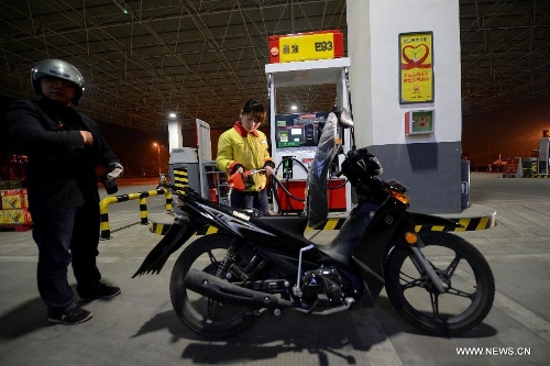 A worker refuels a motorcycle at a gas station in Hefei, capital of east China's Anhui Province, April 25, 2013. Retail prices of gasoline were cut by 395 yuan (63.32 U.S. dollars) per tonne and diesel by 400 yuan per tonne from Thursday. (Xinhua/Zhang Duan) 