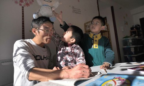 Zhang Qiaofeng corrects children's homework at his home. The Peking University graduate quit his job to educate his own child and other youngsters. Photo: CFP