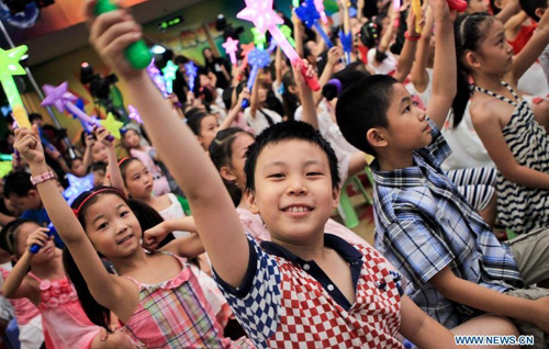 Little audiences cheer during a promoting activity of the Children's Channel of China Central Television (CCTV) in Beijing, capital of China, July 7, 2012. A series of new programs will be presented at the channel during the summer vacation. Photo: Xinhua