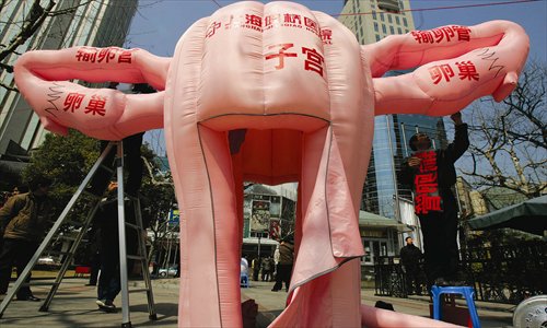 Workers set up a 3-meter high model of a uterus at a park in Shanghai. Visitors can walk into it and see tumors growing inside. The activity aims to raise awareness  of women's health. Photo: CFP